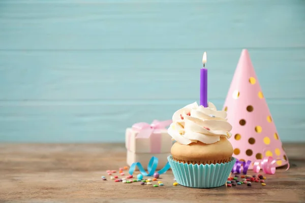 Composición con cupcake de cumpleaños en mesa de madera contra la luz —  Fotos de Stock