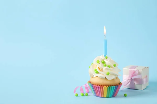 Geburtstagskuchen mit Kerze und Geschenkbox auf hellblauem Hintergrund — Stockfoto
