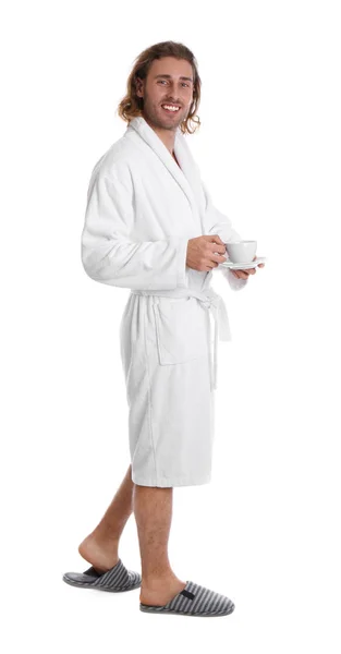 Jovem de roupão de banho com xícara de bebida sobre fundo branco — Fotografia de Stock