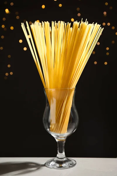 Niegotowane Spaghetti Szarym Stole Przy Rozmytych Światłach Makaron Włoski — Zdjęcie stockowe