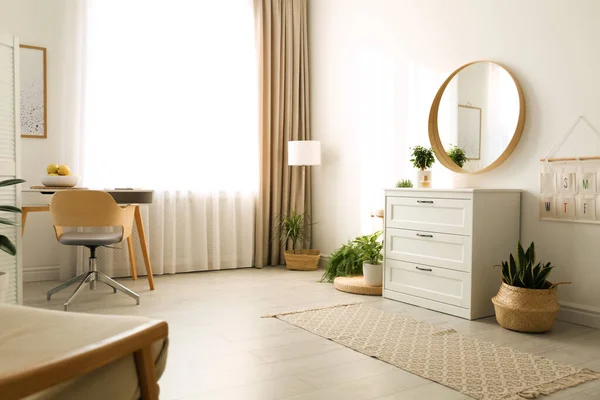 Stylish room interior with chest of drawers and round mirror — ストック写真