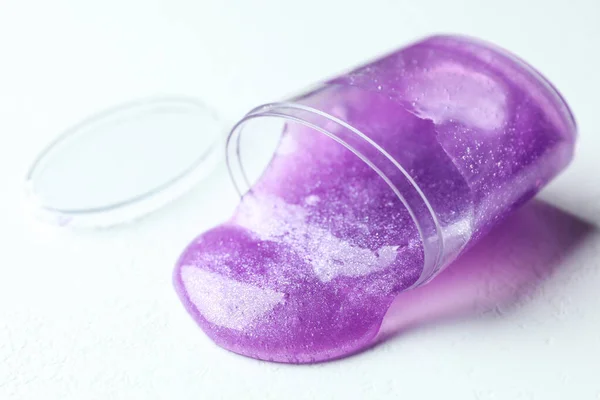 白地に紫色のスライムで覆ったプラスチック製の容器 — ストック写真