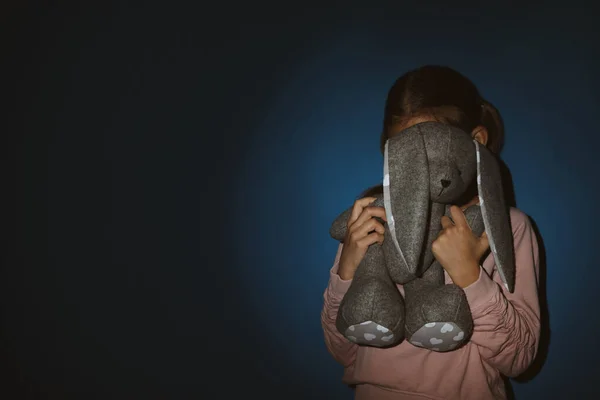 Menina com brinquedo perto da parede azul, espaço para texto. Doméstico vi — Fotografia de Stock