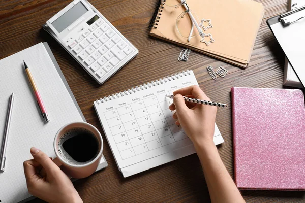 Woman Marking Date Calendar Wooden Table Top View — ストック写真