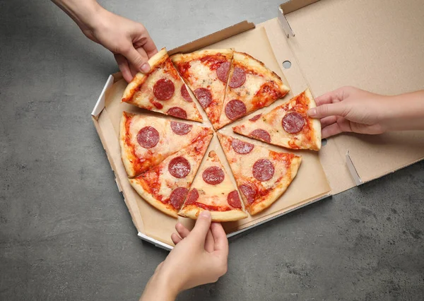 Persone Che Prendono Fette Gustosa Pizza Salame Piccante Tavolo Grigio — Foto Stock