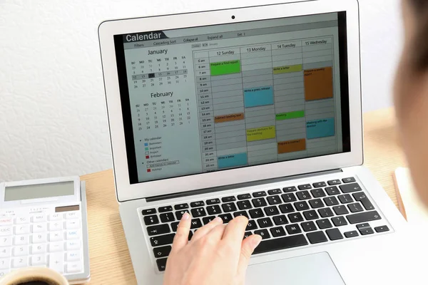 女性在办公室的笔记本电脑上使用日历应用程序 特写镜头 — 图库照片