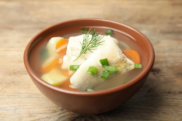 在木制桌子上的碗里放上美味的鱼汤 — 图库照片