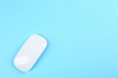 Açık mavi arka planda modern kablosuz optik fare, üst görünüm. Metin için boşluk