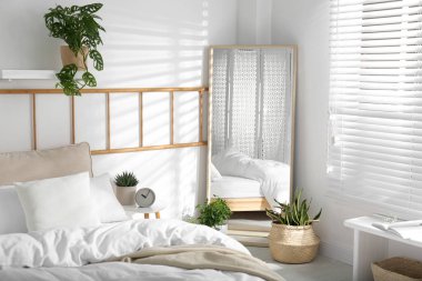 Modern yatak odasının içinde büyük bir ayna var.