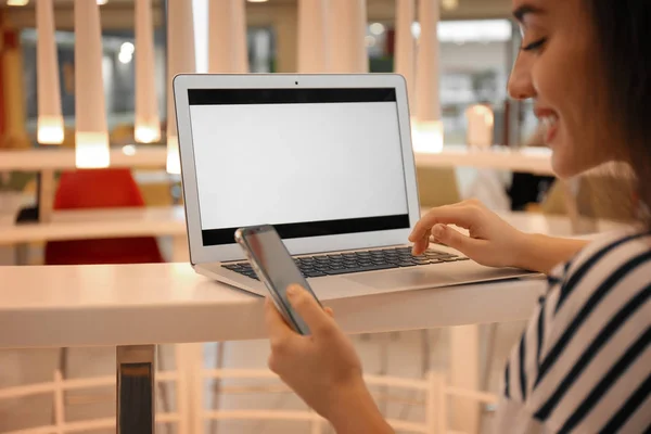 Блогер з ноутбуком і мобільним телефоном в кафе, крупним планом — стокове фото