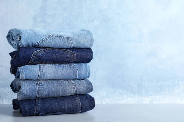 Stack Olika Jeans Ljusbord Mot Blå Bakgrund Plats För Text — Stockfoto