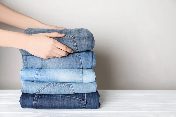 Mulher Jeans Elegante Dobrável Sobre Mesa Madeira Branca Close Espaço — Fotografia de Stock