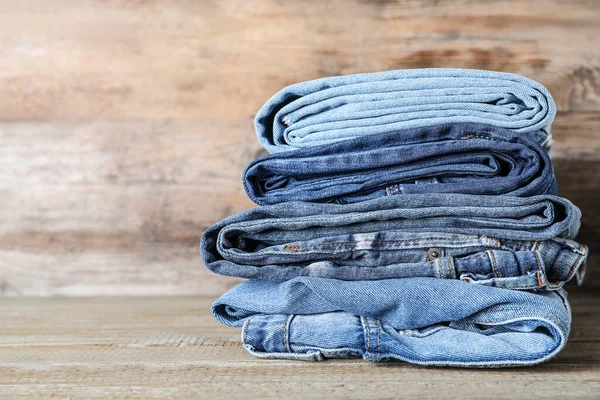 Pilha Jeans Diferentes Mesa Madeira Espaço Para Texto — Fotografia de Stock
