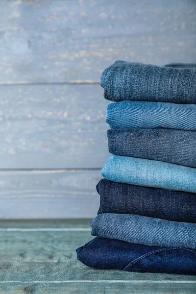 Stapel Verschillende Jeans Blauwe Houten Tafel Ruimte Voor Tekst — Stockfoto