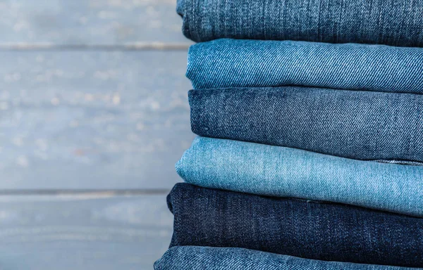 Stack Olika Jeans Grå Trä Bakgrund Närbild — Stockfoto