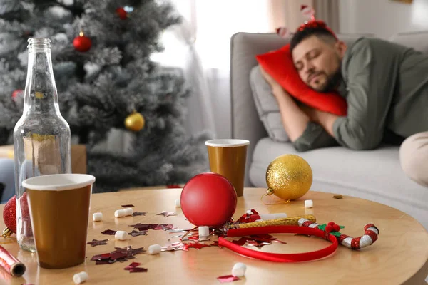 男は新年のパーティーの後に寝て 乱雑なテーブルに焦点を当てる — ストック写真