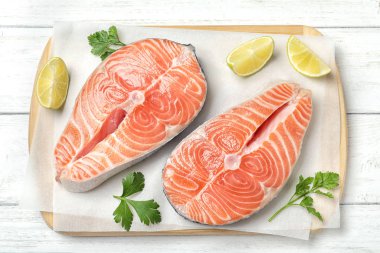 Maydanozlu taze çiğ somon ve beyaz ahşap masada limon.