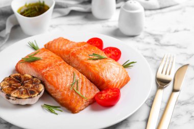 Lezzetli kavrulmuş balık beyaz mermer masada servis edilir.