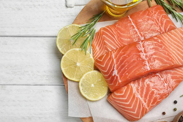 Vista superior de salmão cru fresco e produtos em mesa de madeira branca . — Fotografia de Stock