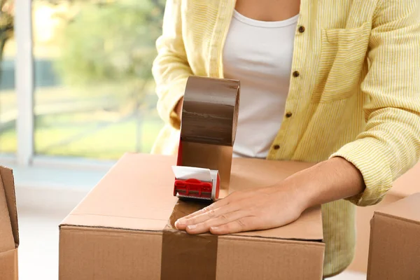 Caixa de embalagem mulher dentro de casa, close-up. Dia de mudança — Fotografia de Stock