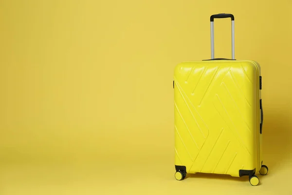Стильный чемодан на желтом фоне. Пространство для текста — стоковое фото