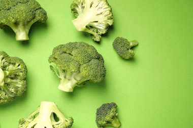 Fresh broccoli on green background, flat lay clipart