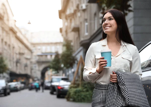 Vacker kvinna i snygg kostym med kopp kaffe på city stree — Stockfoto