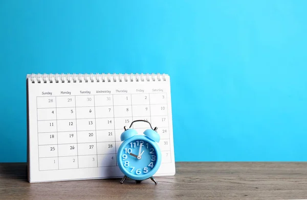 Calendário Despertador Mesa Madeira Contra Fundo Azul Claro Espaço Para — Fotografia de Stock