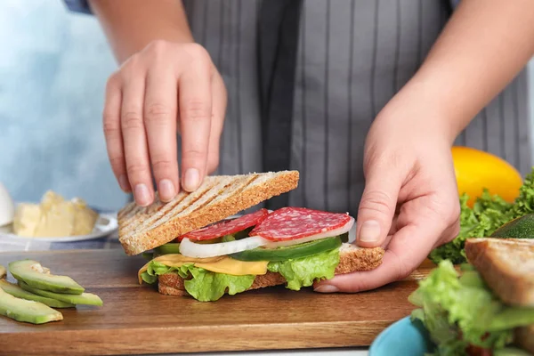 Mulher Fazendo Saboroso Sanduíche Com Salsicha Mesa Close — Fotografia de Stock