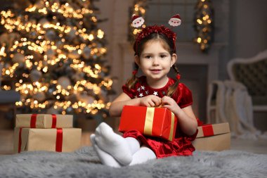 Oturma odasında Noel hediyesi olan şirin bir çocuk.