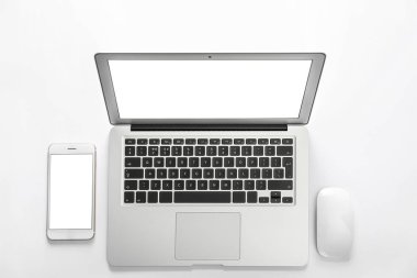 Beyaz arka planda modern dizüstü bilgisayar ve akıllı telefon, üst görünüm