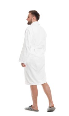 Beyaz arka planda bornoz giyen yakışıklı bir adam.