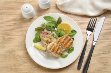 Lezzetli ızgara balık ahşap masada servis edilir.