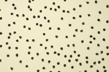 Delicious chocolate chips on beige background, top view clipart