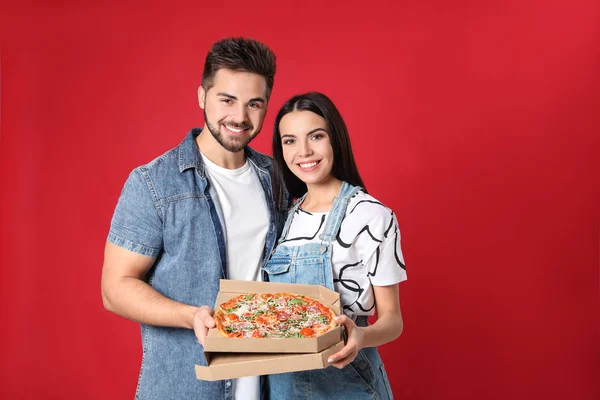 Feliz Joven Pareja Con Pizza Sobre Fondo Rojo — Foto de Stock