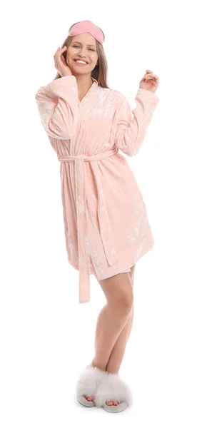 Young woman in bathrobe with sleep mask on white background — Stock Photo, Image