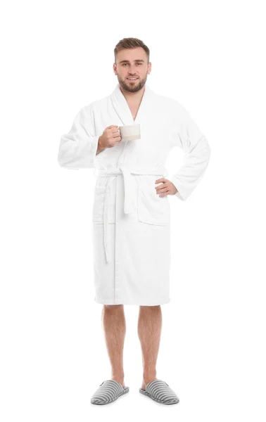 Bello uomo con tazza di caffè indossando accappatoio su sfondo biancogr — Foto Stock