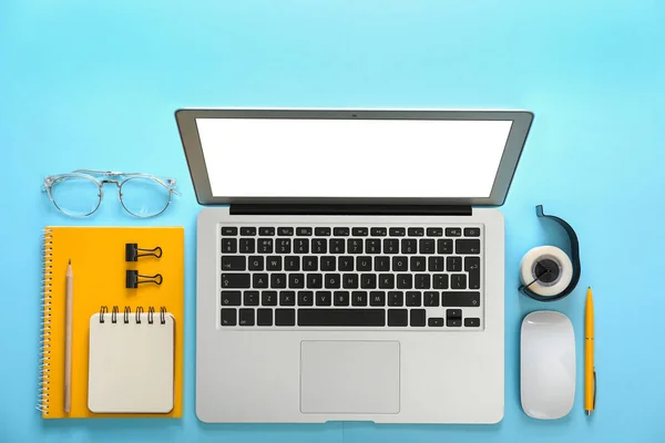 浅蓝色背景的笔记本电脑和办公文具，平铺 — 图库照片