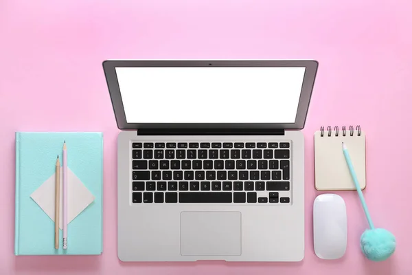 Nowoczesny laptop i biurowa papeteria na różowym tle, płaski leżak — Zdjęcie stockowe