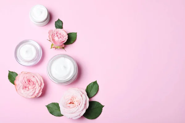 Flat lay composition with jars of organic cream and flowers on p — ストック写真