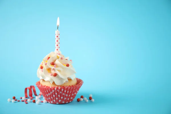 Delicioso cupcake de aniversário com vela no fundo azul claro . — Fotografia de Stock