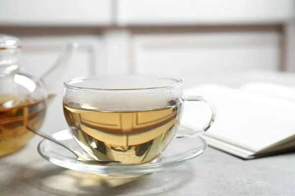 Leckerer heißer grüner Tee in Tasse auf grauem Tisch, Nahaufnahme — Stockfoto