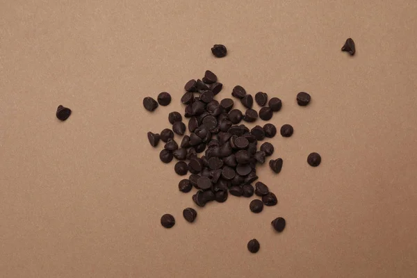 Pile των νόστιμων τσιπ σοκολάτας σε καφέ φόντο, top view — Φωτογραφία Αρχείου