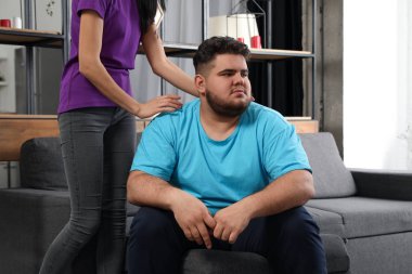 Kadın evde depresyondaki kilolu arkadaşını teselli ediyor.