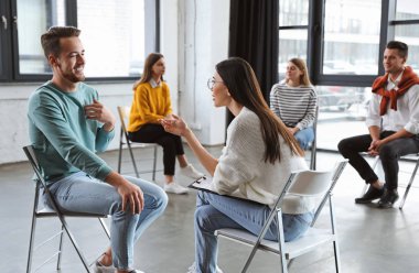 Psychotherapist working with patient in group therapy session indoors