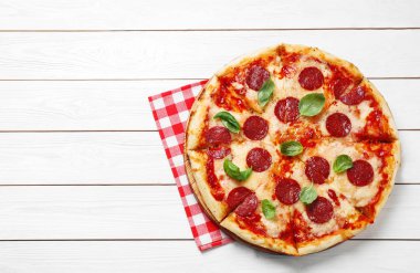 Beyaz ahşap masa üzerinde sıcak, lezzetli pepperoni pizza, üst manzara. Metin için boşluk