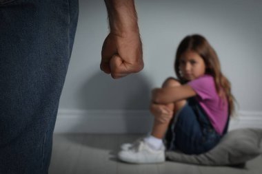 Kızını içeride tehdit eden bir adam, yakın plan. Aile içi şiddet