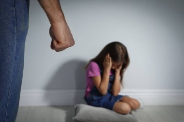 Kızını içeride tehdit eden bir adam, yakın plan. Aile içi şiddet