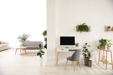 Yeşil saksı bitkileriyle dekore edilmiş modern bir iş yeri. Ev tasarımı