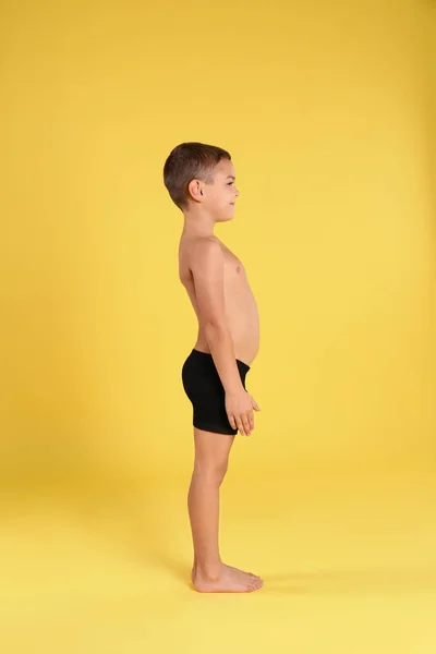 Lindo niño en ropa interior sobre fondo amarillo — Foto de Stock